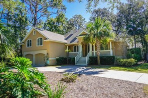A two-story house with a front porch, a garage, and a well-maintained lawn.