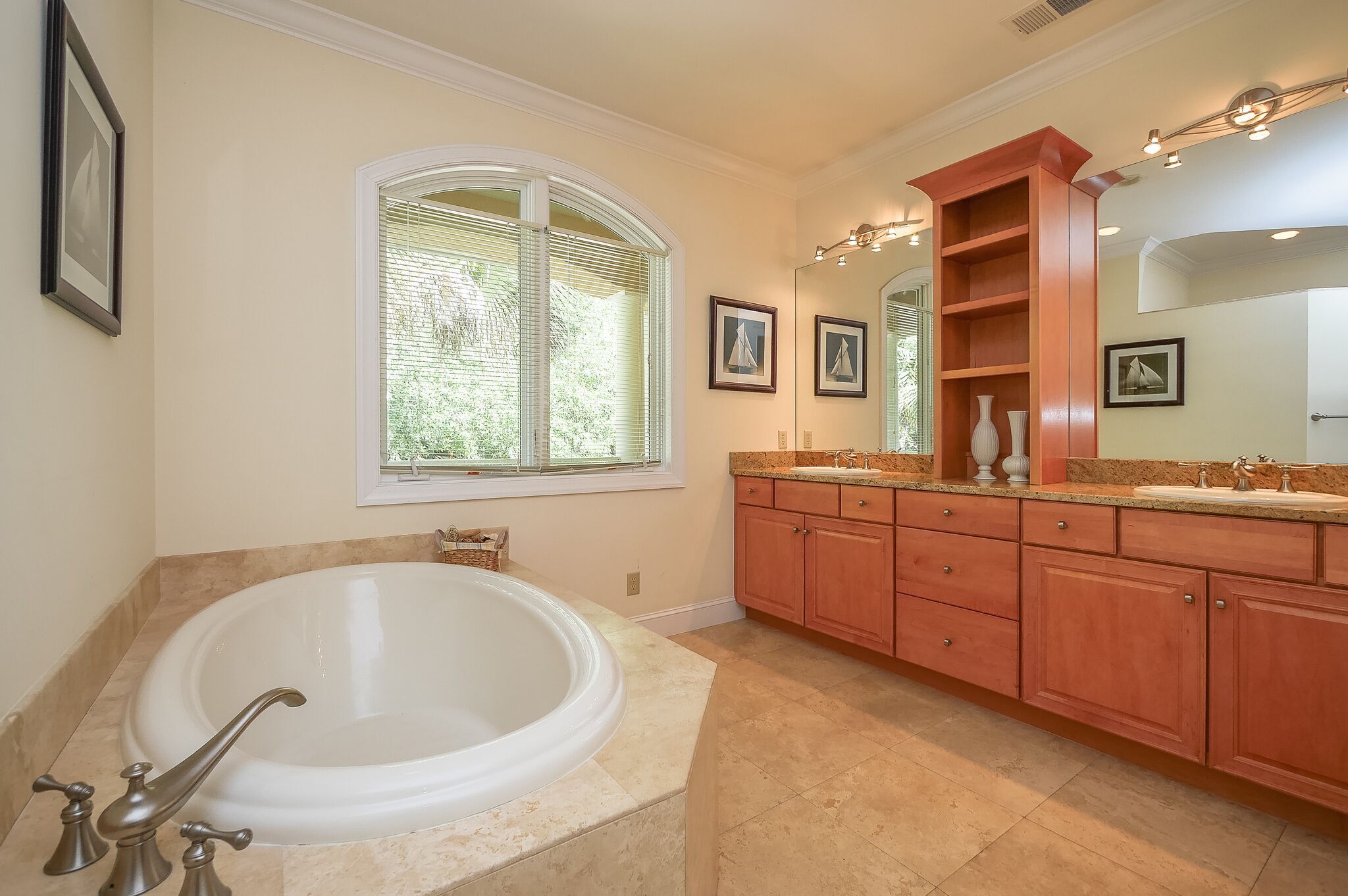 A spacious bathroom with a large bathtub, a vanity with a sink, and a mirror.