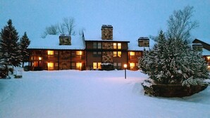 Ein großes Holzhaus mit vielen Fenstern und einer schneebedeckten Landschaft.