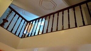A staircase with wooden balusters and a geometric ceiling design.