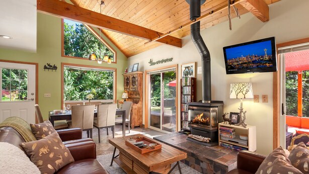 Una sala de estar acogedora con chimenea, sofás de cuero y un televisor.