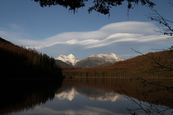 Ein ruhiger See spiegelt Berge und Bäume wider.