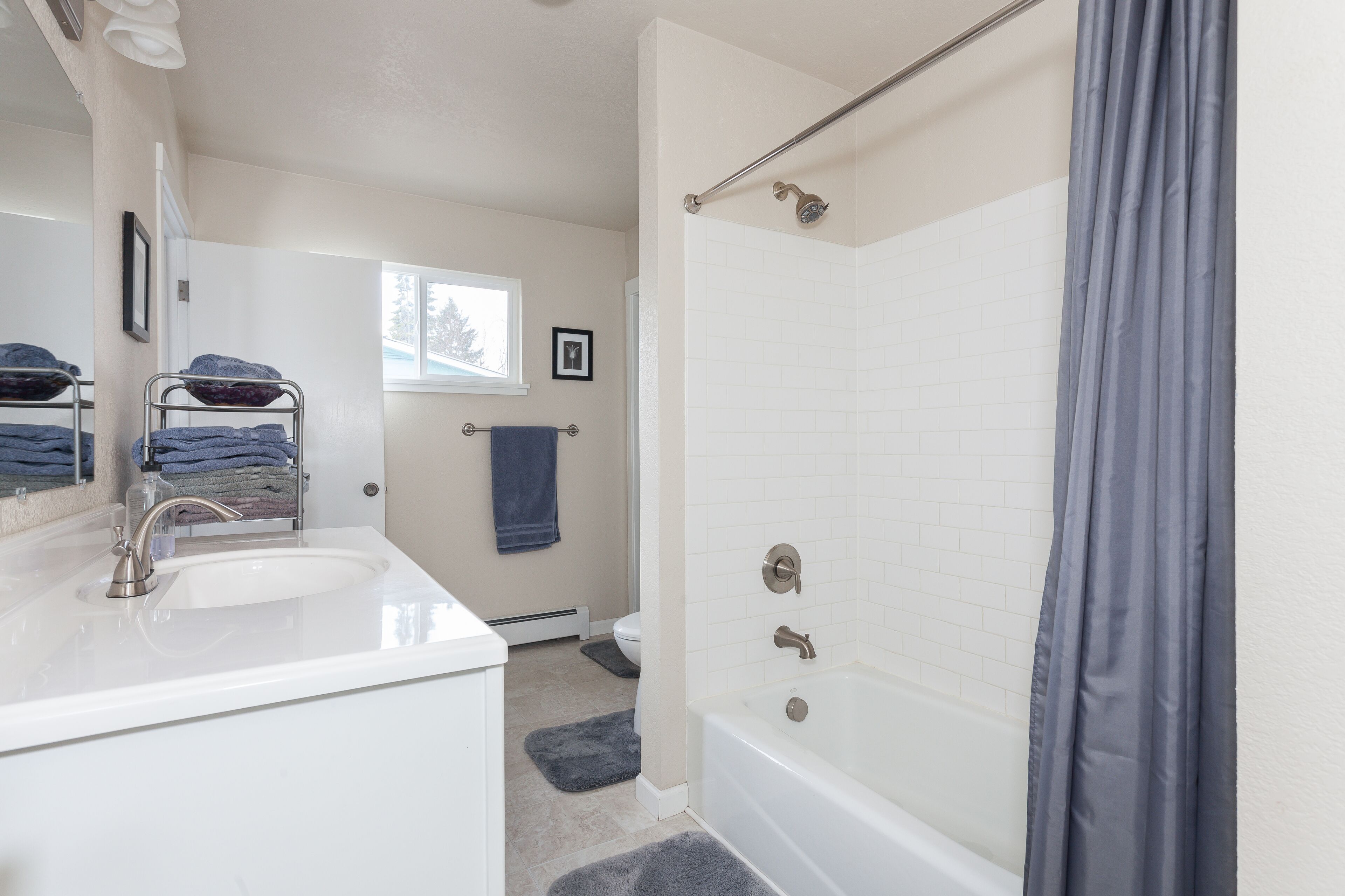 Un baño con lavamanos blanco, bañera y cortina de ducha.