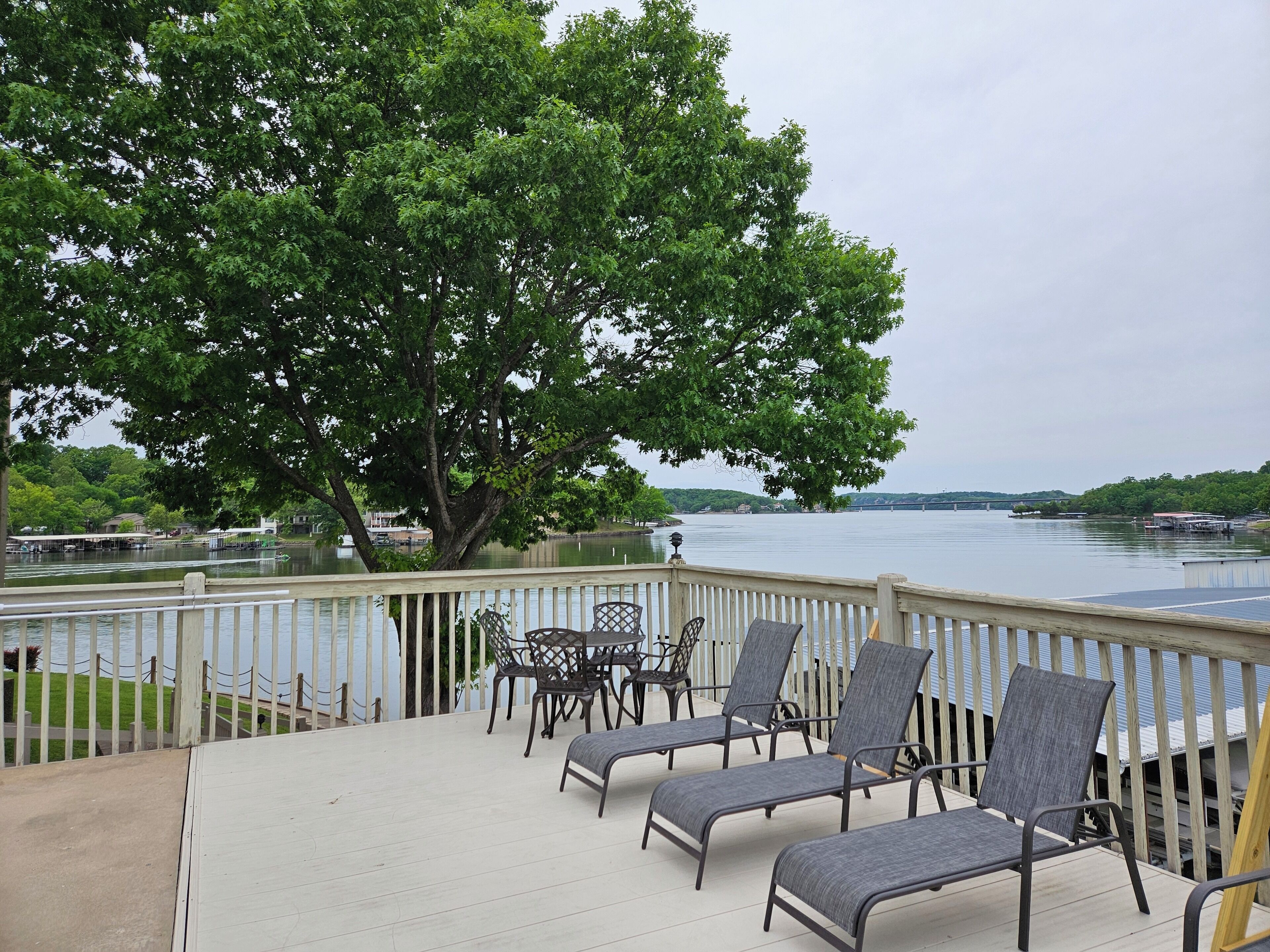 A deck with outdoor seating and a view of a lake.