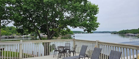 A deck with outdoor seating and a view of a lake.