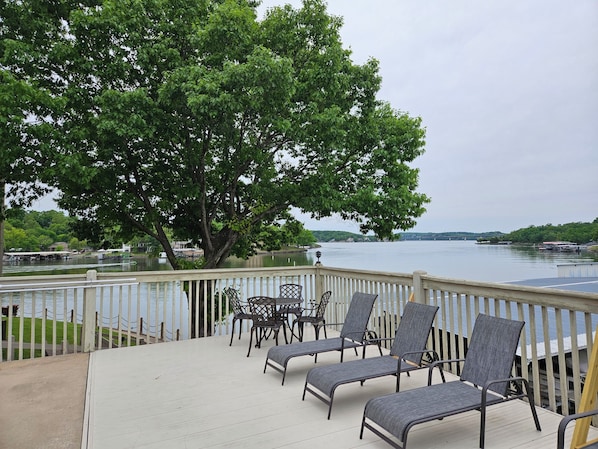 A deck with outdoor seating and a view of a lake. - Special Dec to April long term stay. Inquire with owner for travel options. (Osage Beach)