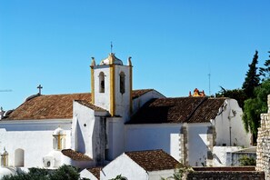 Une église blanche dotée d’un clocher et d’un toit recouvert de tuiles.