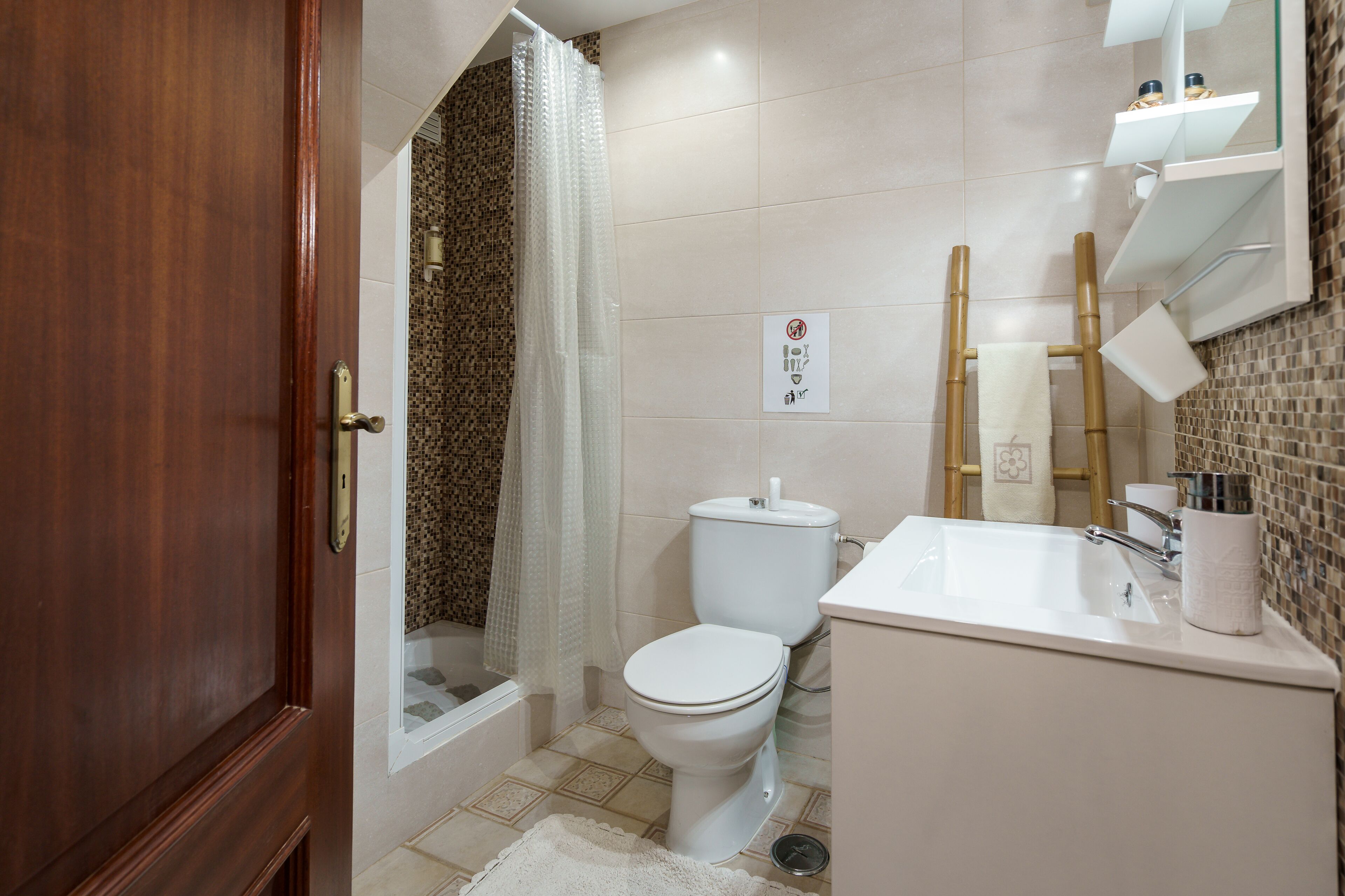 Une salle de bain comprenant des toilettes, un lavabo et un espace douche.