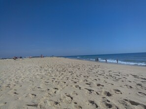 A wide sandy beach with footprints, a clear sky, and the ocean in the background. - Apartment in a House (Tavira)