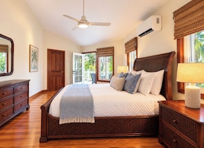 A bedroom with a large bed, wooden headboard, and a ceiling fan. - Casa Kennedy - Family Beach Home - Last Private House on West Bay Beach (West Bay)
