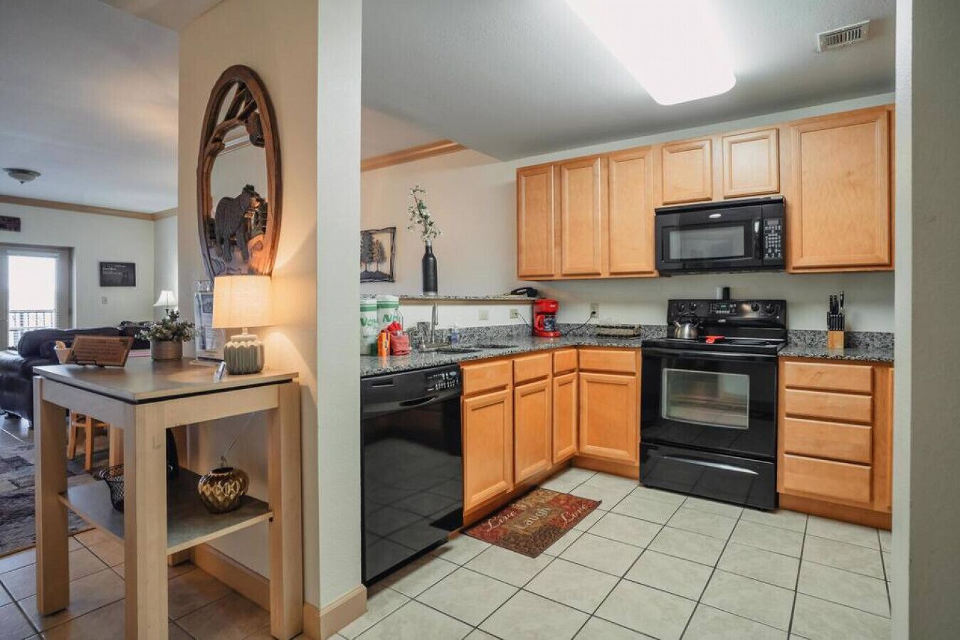 A modern kitchen with wooden cabinets, a microwave, stove, and a dishwasher.