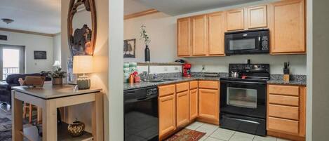 A modern kitchen with wooden cabinets, a microwave, stove, and a dishwasher.