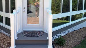 A house with a covered porch, a front door, and a small step leading up to it. - Come and enjoy a beautiful view and relaxing time at Windy Knoll.... (Afton)