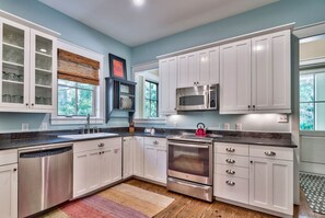 Enjoy cooking in this well-equipped kitchen with a large window offering a view of the surrounding greenery.