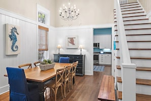 A dining area with a wooden table, blue chairs, and a chandelier.