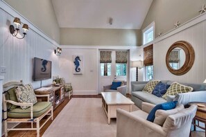 Uma sala de estar acolhedora com lareira, televisão e um espaço de jantar com mesa e cadeiras.