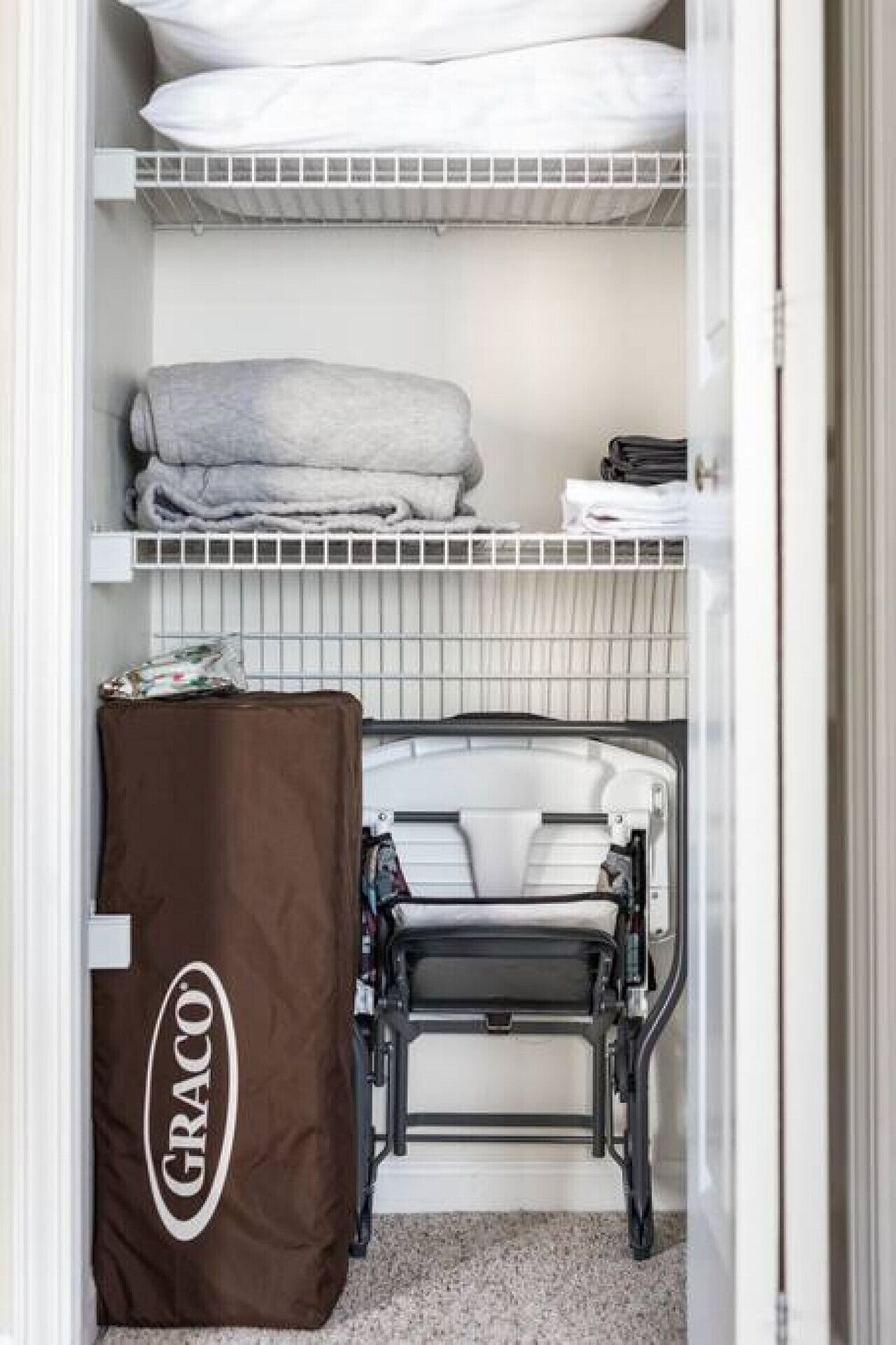 A compact storage unit with a Graco brand mattress protector.