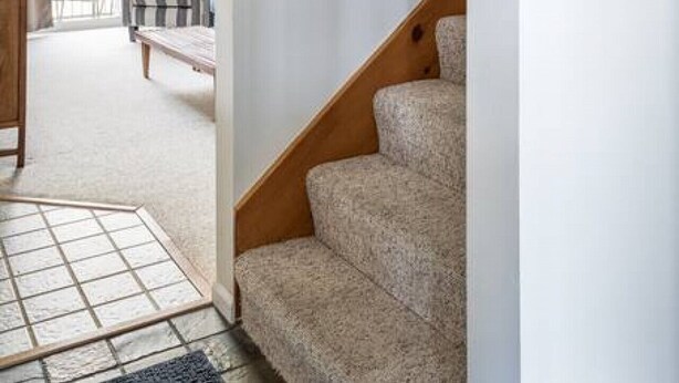A staircase with wooden handrails leading to a landing.