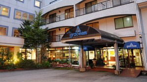 A hotel with a modern design, featuring multiple balconies and a covered entrance.
