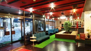 A modern interior with seating areas, a reception desk, and a view of the outside.