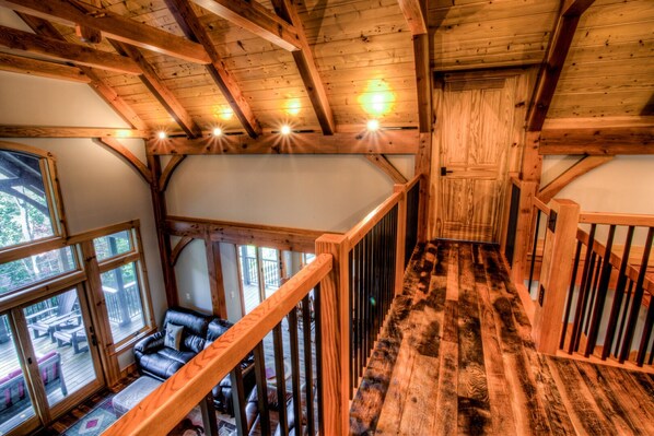 A wooden interior with a staircase, large windows, and a view of the outdoors. - Rustic Timber | 5-Bedroom Pet Friendly Black Mountain Retreat with Views (Fairview)