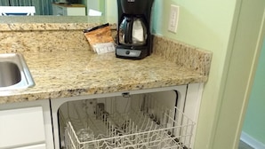 A kitchen with a granite countertop, a coffee maker, and a dishwasher. - Ocean View Condo@Beach Front Resort 150' Waterslide Indoor Pool Tennis Mini Golf (Atlantic Beach)