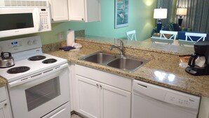A kitchen with white appliances, a granite countertop, a stainless steel sink, and a dishwasher. - Ocean View Condo@Beach Front Resort 150' Waterslide Indoor Pool Tennis Mini Golf (Atlantic Beach)