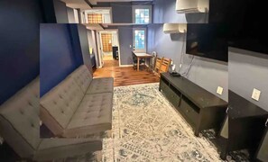 Una habitación con sofá, televisión y mesa de comedor.