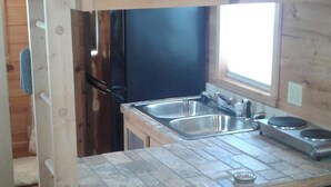 A compact kitchen with a wooden countertop, a sink, and a stove. - The Tiny House Experience 6m North of Mnt. View Ark. on N. Riverview  Rd Cr 186  (Mountain View)