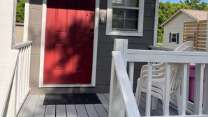 A house with a red door, a small window, and a porch with white railings. - The Tiny House Experience 6m North of Mnt. View Ark. on N. Riverview  Rd Cr 186  (Mountain View)