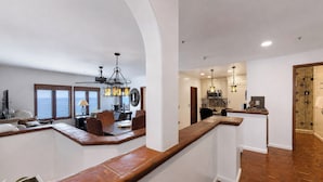 Amplia sala de estar con techos altos, una cocina equipada con electrodomésticos modernos y vistas al océano a través de amplios ventanales.