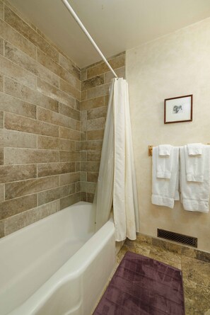 Bathtub, hair dryer, towels, shampoo