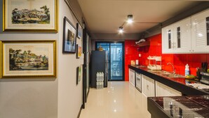 Een moderne keuken met een rode achterwand, roestvrijstalen apparatuur en een wanddecoratie.