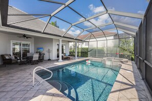 A covered outdoor swimming pool with a patio area, seating, and a hot tub. - Waterfront Home | Pool, Spa & Direct Boating Access (Marco Island)