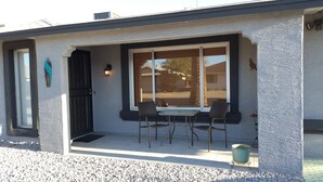 Un bâtiment doté d’un patio couvert comprenant deux chaises et une table.