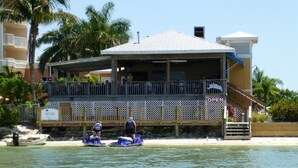 A beachfront building with a covered deck and a sign indicating it is open. - Lovers Key Resort, Luxury Top Floor Penthouse with Best Views in the Resort (Fort Myers Beach)
