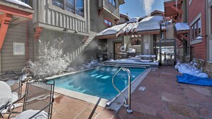 A pool area with a hot tub, lounge chairs, and a view of a multi-story building with balconies. - 7 Mi to Copper Mtn: Condo w/ Deck & Stunning Views (Frisco)