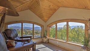 A cozy interior with a wooden ceiling, leather furniture, and large windows offering a mountain view. - 7 Mi to Copper Mtn: Condo w/ Deck & Stunning Views (Frisco)