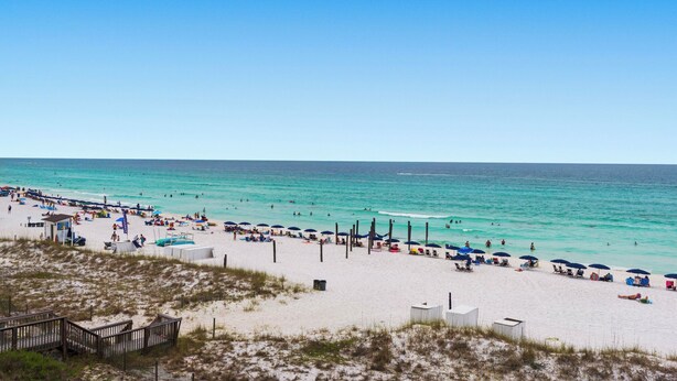 A beach with clear turquoise water, sandy shore, and beach umbrellas. - BeachFront, Bch Svc, pool, wifi, Kitchen, grill (Destin)