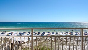 A beach with umbrellas and sun loungers, a wooden deck, and a view of the ocean. - BeachFront, Bch Svc, pool, wifi, Kitchen, grill (Destin)