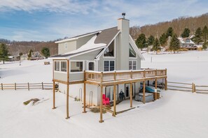 A house with a covered deck and a large chimney.