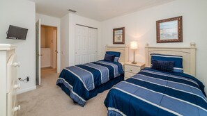 A bedroom with two beds, a TV, a door, and two framed pictures on the wall. - Windsor Hills Resort 5 Bedroom Private Pool+Spa Home (Kissimmee)