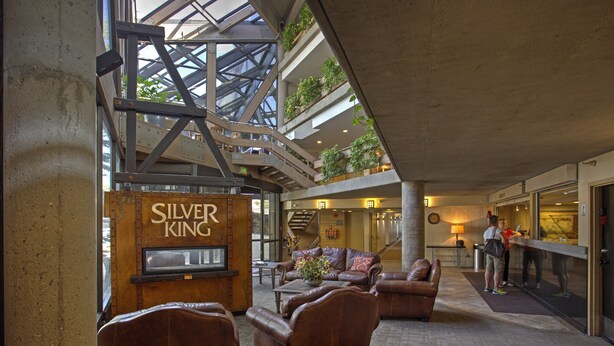 Eine großzügige Lobby mit Ledersofas, einem Couchtisch und einem Schild mit der Aufschrift 'Silver King'.
