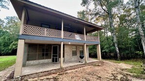Une maison à deux étages dotée d’un balcon, de grandes fenêtres et d’une façade en briques.