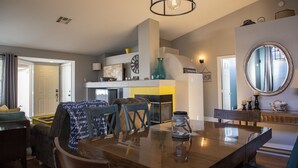 A modern kitchen with a dining area, featuring a wooden table, chairs, and a hanging light fixture. - Pool house Close to the strip 3bedroom pool bungalow  (Las Vegas)