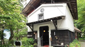 A traditional Japanese building with a wooden exterior, a black and white facade, and a small entrance. - Yokokura-inn (Nagano)