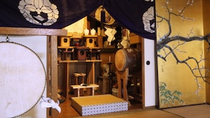 A traditional Japanese room with tatami flooring, a shoji screen, and various traditional items like a drum and a statue. - Yokokura-inn (Nagano)