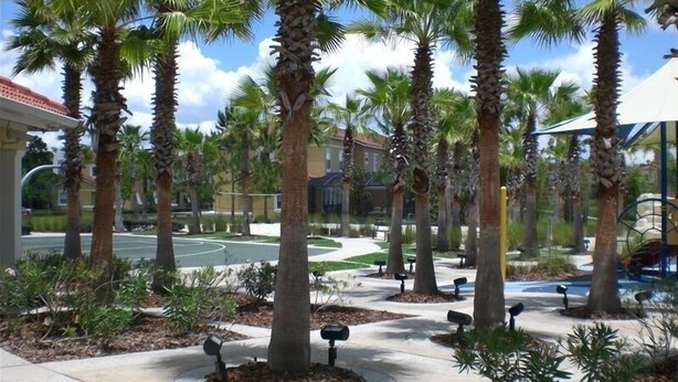 A landscaped area with palm trees, benches, and a paved walkway. - Special rates available for Sep, Oct 2026 (Kissimmee)