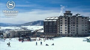 Sheraton Steamboat Resort Villas with a ski slope and buildings in the background. - Sheraton 2BR, 2BA. 100% mountain-front ski in & out.  New Years Week! 1,627 sqft (Steamboat Springs)