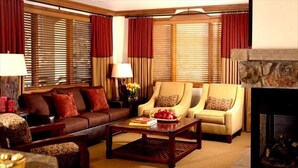 A cozy living room with a sofa, armchairs, a coffee table, and a fireplace. - Sheraton 2BR, 2BA. 100% mountain-front ski in & out.  New Years Week! 1,627 sqft (Steamboat Springs)